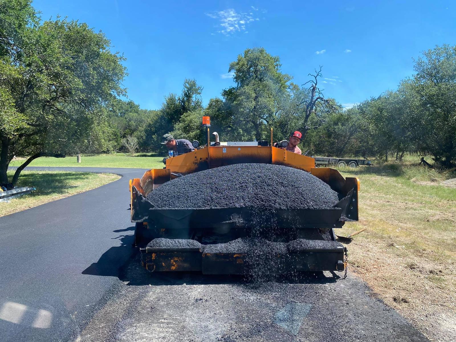 Asphalt paving machine laying hot mix on a commercial approach