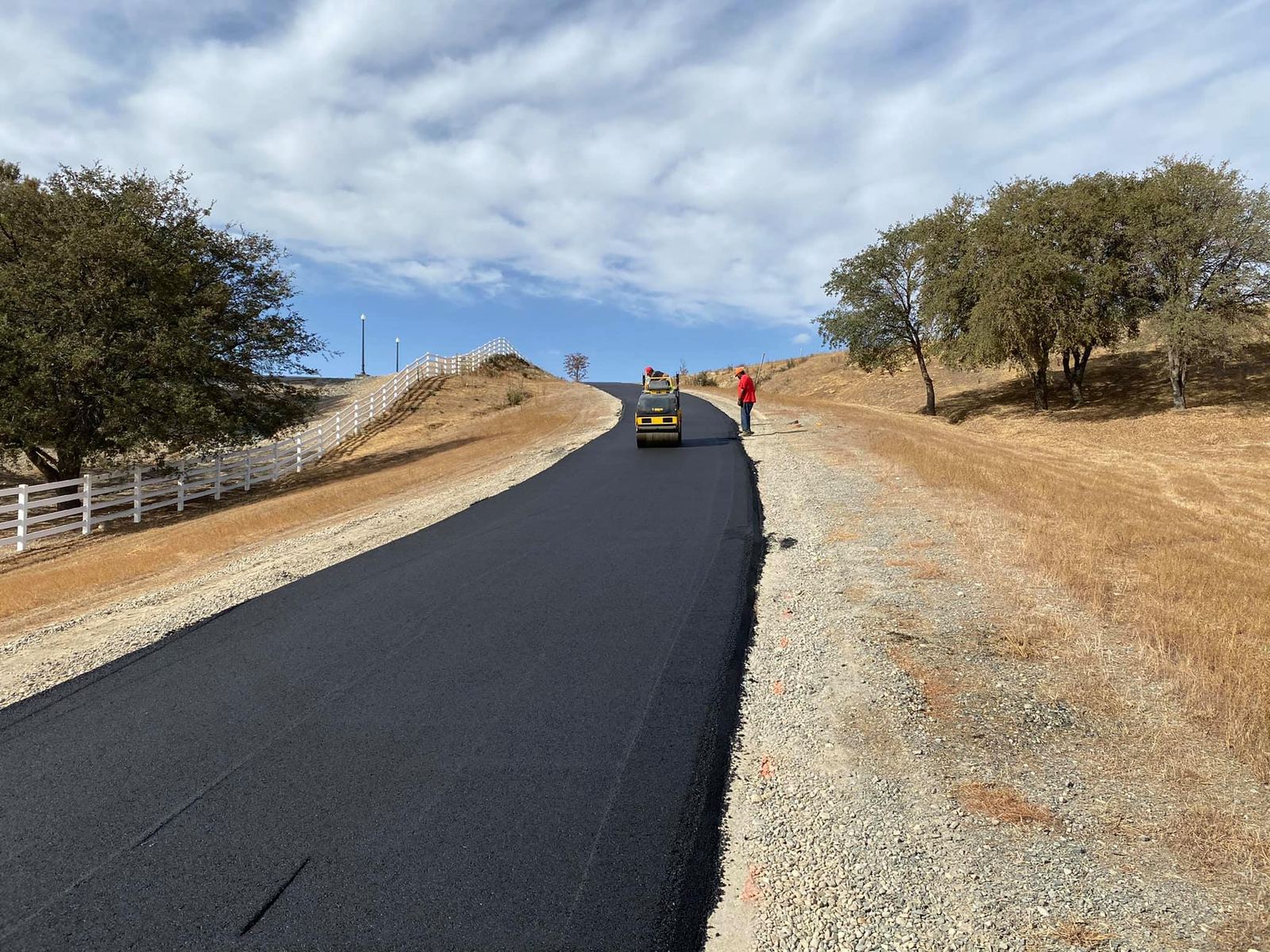 Roller compacting a freshly paved private road